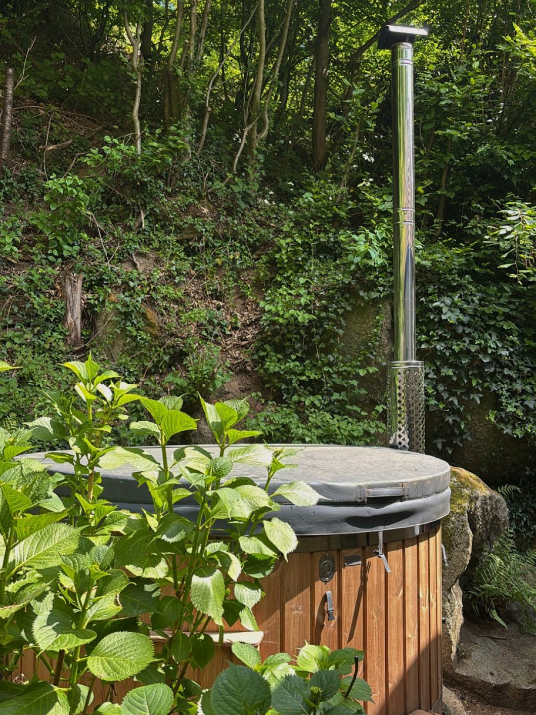 Wooden hot tub in natural garden setting